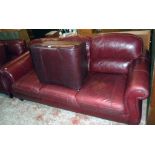 A 7' 3" modern three seater settee upholstered in oxblood coloured leather - sold with an associated