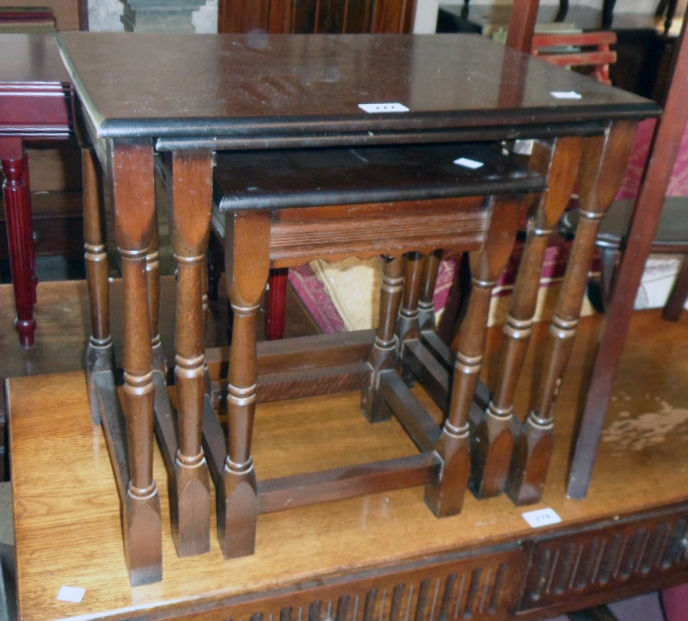 A nest of three modern stained wood tea tables, set on slender turned supports