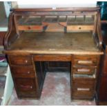 A 3' 6" early 20th Century Angus oak roll-top desk with tambour enclosing a part fitted interior