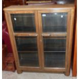 A 36" Art Deco stained mixed wood book cabinet with adjustable shelves enclosed by a pair of