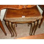 A nest of three reproduction quarter veneered mahogany tea tables with glass tops and moulded