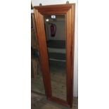 A modern waxed pine framed narrow oblong wall mirror