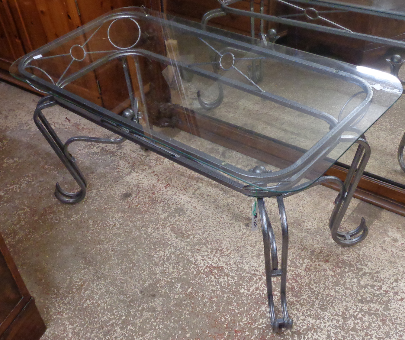 A rectangular wrought iron table with glass top