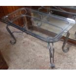 A rectangular wrought iron table with glass top
