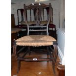 An Edwardian stained and strung wood framed bedroom chair with woven rush seat and slender