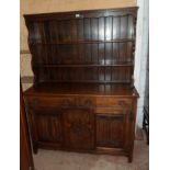 A 4' 6" 20th Century polished oak two part dresser with open plate rack over a base with two short
