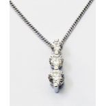 An import marked 750 white gold pendant set with three graduated diamonds, on 750 gold chain