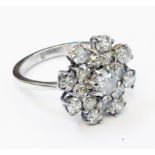 A marked 18ct. white metal diamond encrusted flower head pattern ring - approx 2.5ct. TDW