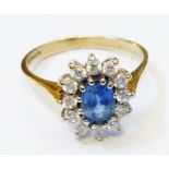 An import marked 375 gold ring set with central oval pale blue sapphire, within a white paste
