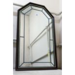 A modern polished wood and leaded framed wall mirror with canted oblong plate