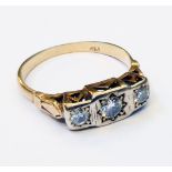 A marked 18k yellow metal ring with three gypsy set diamonds