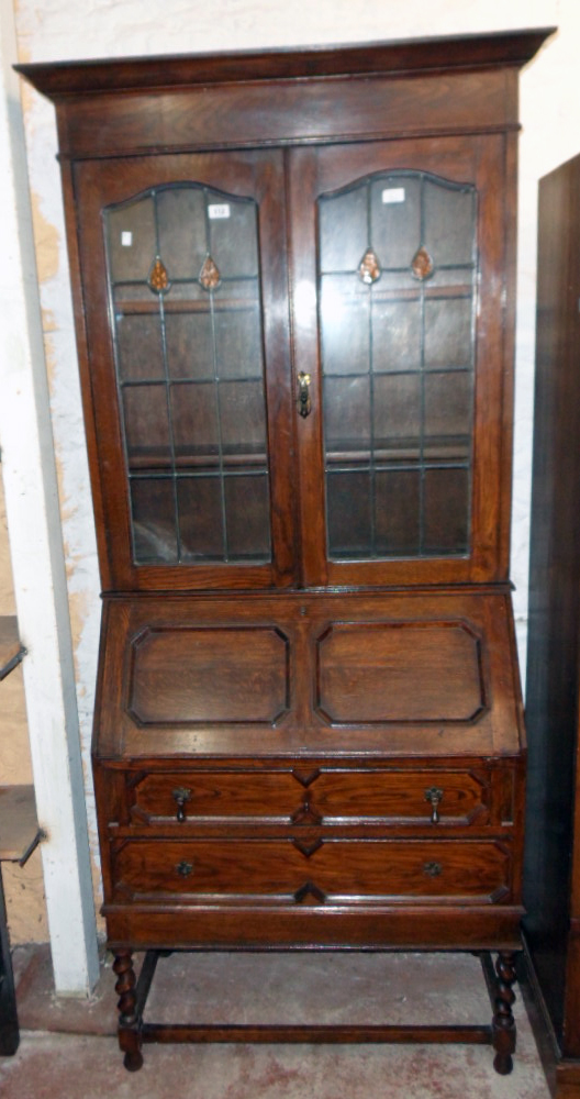 A 3' 2 1/4" early 20th Century polished oak bureau bookcase with shelves enclosed by a pair of