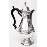 A silver coffee pot of faceted baluster design with flip-top and stepped pedestal foot - marks worn