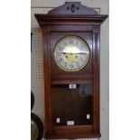 A 20th Century polished oak cased wall clock with visible pendulum and eight day gong striking