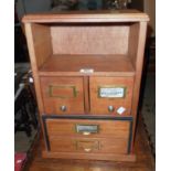 A 13" stained mixed wood table-top filing chest with open shelf and four drawers