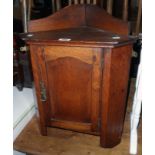 An 18" late Victorian oak wall hanging corner cabinet with canted sides and panel door