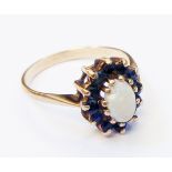 A marked 9ct. yellow metal ring, set with central opal and tiny sapphires