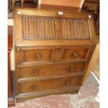 A 30" 20th Century polished oak bureau with linen-fold fall enclosing a part fitted interior with