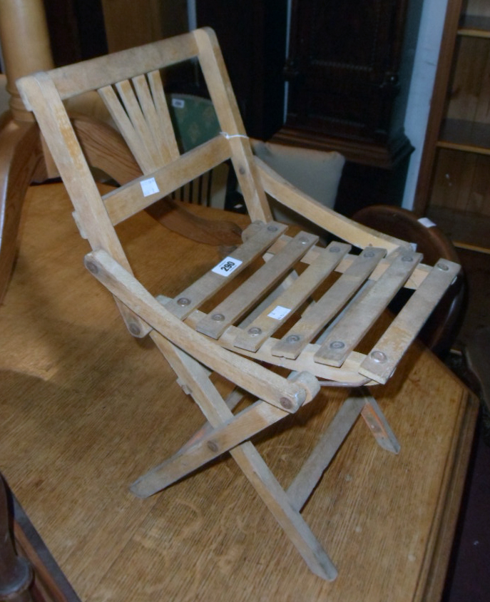 A vintage child's folding chair with slatted seat panel