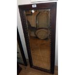 A heavy stained hardwood framed bevelled oblong wall mirror with moulded decoration