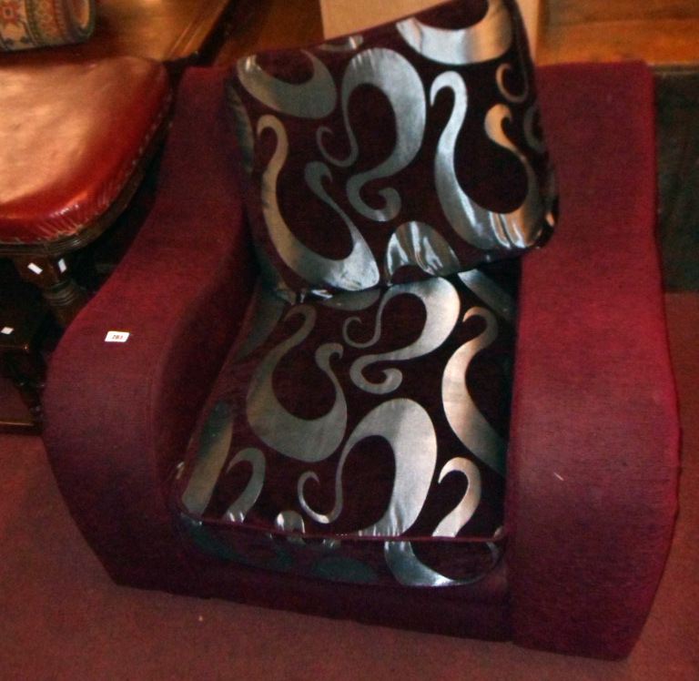 A 3' 6" late 20th Century Art Deco style armchair upholstered in burgundy velour with contrasting