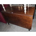 A 3' 6" antique mahogany drop-leaf dining table, set on square tapered legs