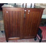 A 3' 11 1/2" Edwardian walnut linen press with five slides enclosed by a pair of panelled doors -
