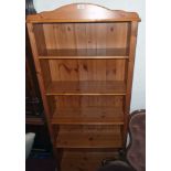 A 30 1/2" modern polished pine five shelf open bookcase with moulded top and bun feet