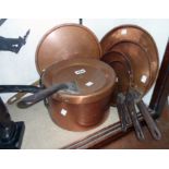 A copper pan with iron handle - sold with a set of four copper pan lids and two further similar