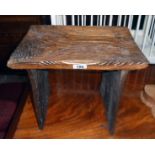 A rustic polished wood stool with relief decoration depicting stylised trees to standard ends -