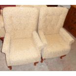 A pair of Sherborne armchairs upholstered in repeat foliate scroll material, set on polished wood