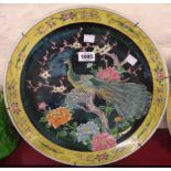An Japanese late Meiji period Famille Noire charger depicting peacock and hen among chrysanthemum