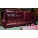A 7' 3" modern three seater settee upholstered in oxblood coloured leather - sold with a locker