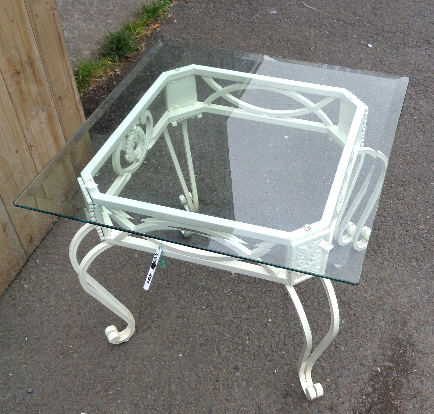 A square wrought iron table with glass top