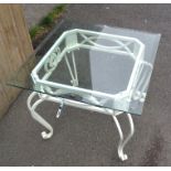 A square wrought iron table with glass top