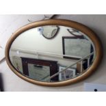 A giltwood framed bevelled oval wall mirror