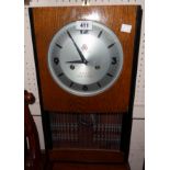 A vintage Chinese polished oak and ebonised case wall clock with visible pendulum and fifteen day