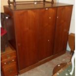 A 5' 11 1/2" mid 20th Century teak effect triple wardrobe with hanging space and shelves enclosed by