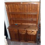 A 4' 2" modern polished pine two part dresser with open plate rack over a base with three drawers