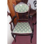 An Edwardian stained wood framed elbow chair with upholstered back and seat panels, set on