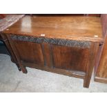 A 3' 6" oak two panel coffer with moulding and carved decoration, set on simple block feet