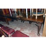 A late Victorian mahogany extending dining table with three leaves and winder, set on heavy cabriole