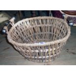 A 21" modern wicker and seagrass bound log basket with flanking metal handles