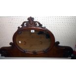 A 3' 6" Victorian walnut framed mirror set raised back section with pierced pediment, oval plate and