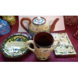 Four pieces of Torquay pottery including teapot, two handled mug, etc.