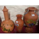 A Torquay Pottery terracotta decanter with floral decoration, vase and similar urn (no lid)