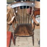 An elm Windsor stick back elbow chair with moulded solid elm seat, set on ring turned supports