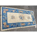 A vintage Chinese rug with central floral motifs within a coin and floral border, blue on beige