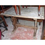 A 3' 4 1/2" vintage stripped oak tavern table, set on shaped standard ends with pegged stretcher