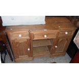A 3' 9" late Victorian pine dresser base with break front top, central drawer and open shelves